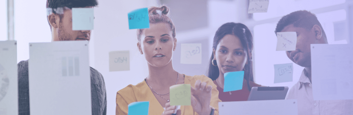 ERG metrics featured image of workers standing in front of a board with sticky notes.