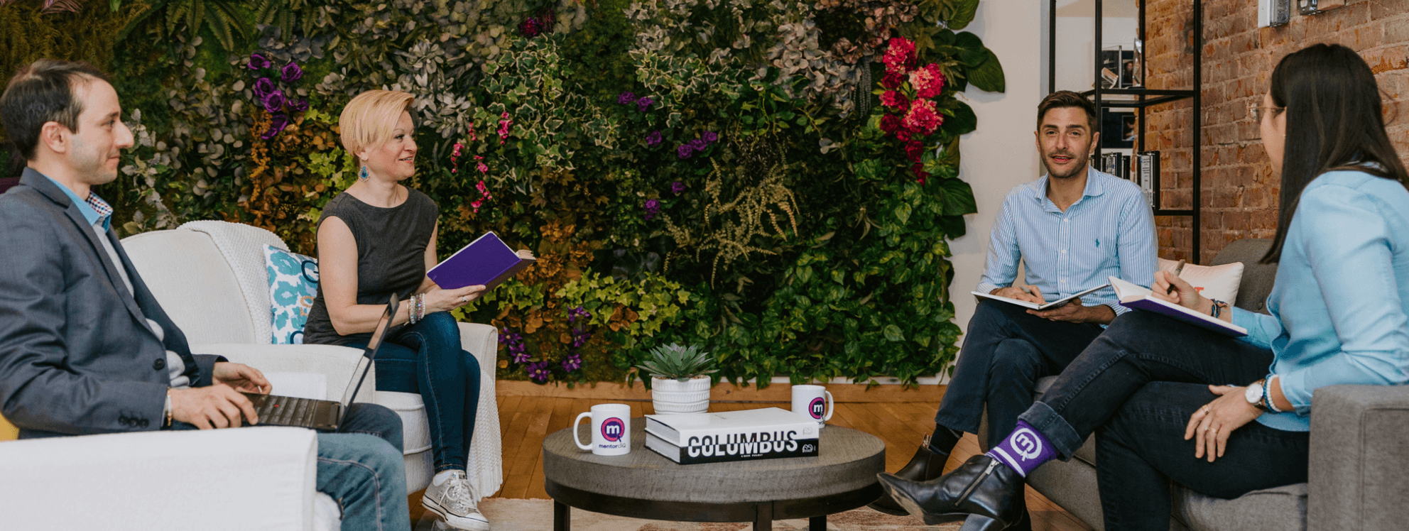 Image of employees in an office living room meeting and chatting on couch and chairs.