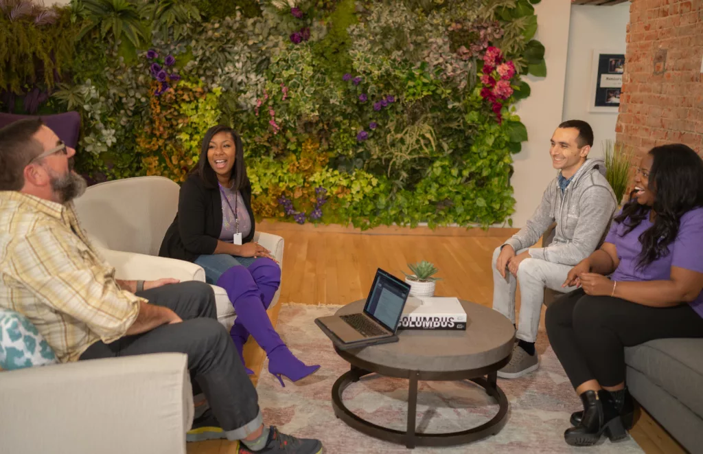 4 team members from Mentorcliq meeting up around a coffee table to discuss mentoring ideas.