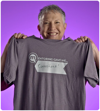 Lisa Graham holding a shirt that says: Mentoring gave me connections