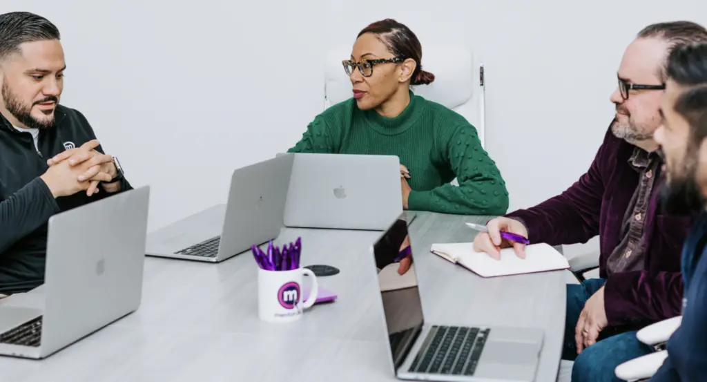 Image of individuals in an office discussing how to be an ally. 