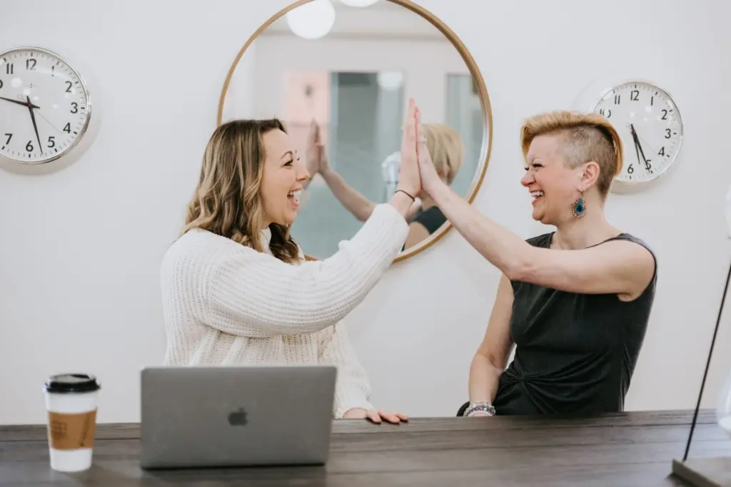 Two women in a Women's ERG celebrating success with a high five. 